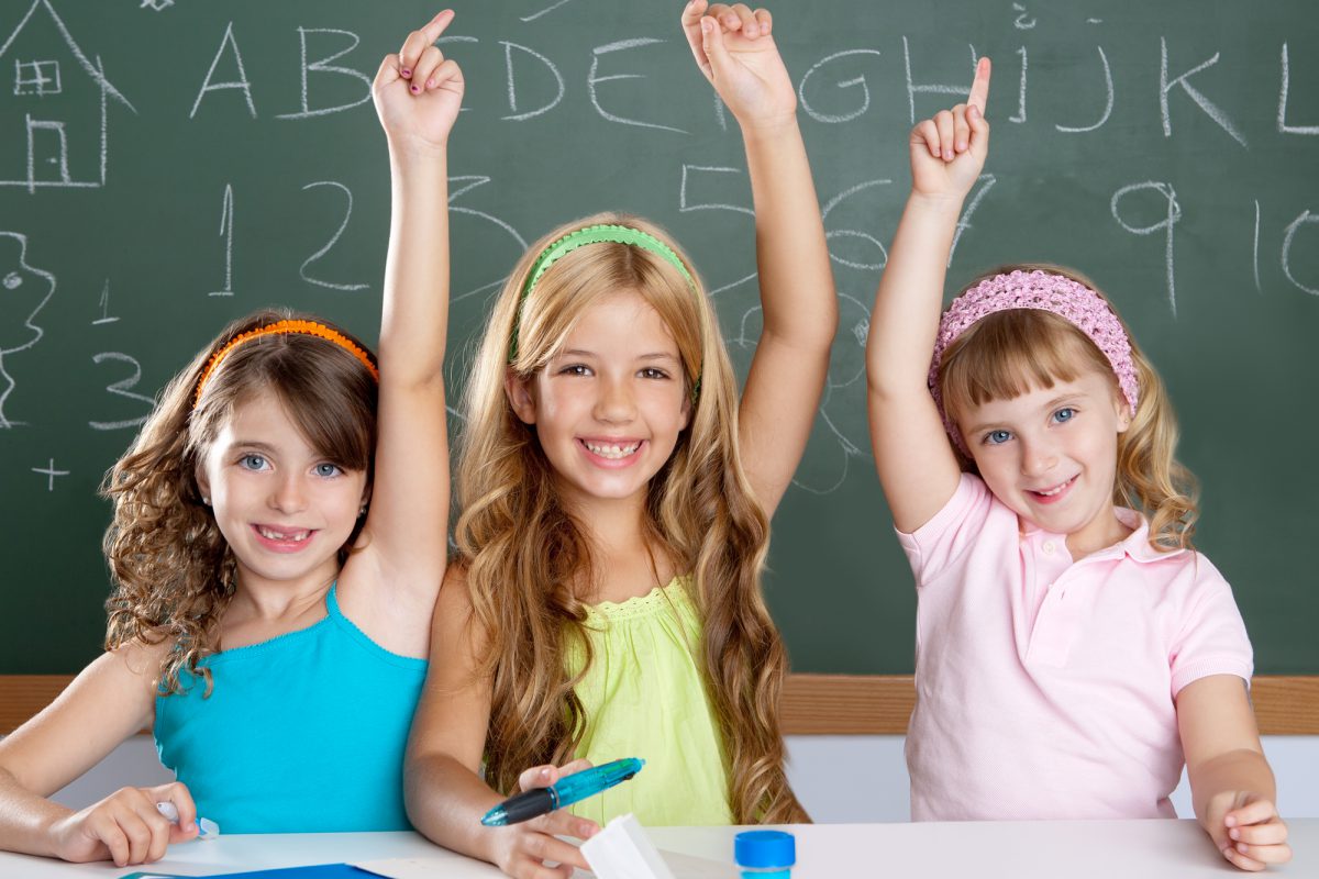 clever kids student group at school classroom raising hand as smart children